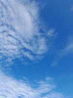 Beautiful white clouds on deep blue sky background. Large bright soft fluffy clouds are cover the entire blue sky. photo