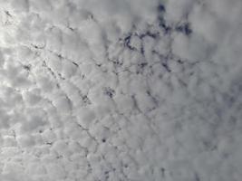 Beautiful white clouds on deep blue sky background. Large bright soft fluffy clouds are cover the entire blue sky. photo