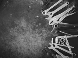 Hand tools consisting of wrenches, pliers, socket wrenches, laid out on old steel plate background. photo