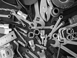 mano herramientas consistente de llaves inglesas, alicates, enchufe llaves inglesas, puesto fuera en antiguo acero plato antecedentes. foto