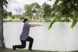 Beautiful asian fat woman play yoga at the park,Need to slim fit body photo