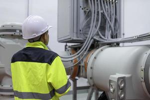 Electrical engineer man checking voltage at the Power Distribution Cabinet in the control room,preventive maintenance Yearly,Thailand Electrician working at company photo