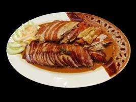 closeup Roasted duck and grilled pork isolate on black background. photo