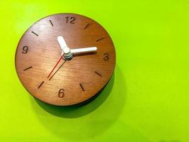 de madera pared reloj en ligero verde cuero hoja. foto