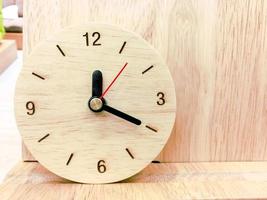 Closeup Wooden wall clock on wood background photo