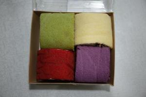 Photo of colourful mini roll cakes in a box
