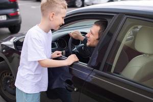 papá llegó hogar en un negro coche. hijo Satisface padre foto