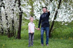 papá camina con su hijo y puntos a el lado con su mano foto