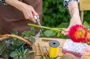 el flujo de trabajo de un florista, poda el hojas de un flor con un podador foto