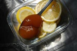 Sliced lemon with a spoonful of honey photo