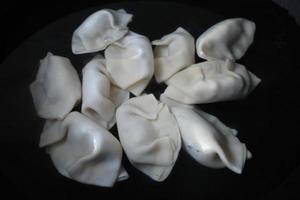 Wontons being boiled in the pot photo
