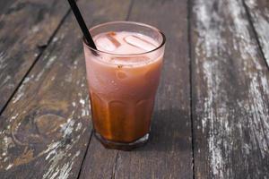 A photo of a glass of red juice isolated on wooden table