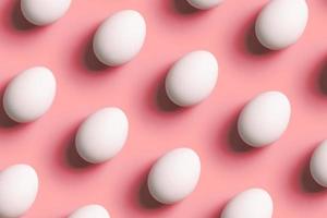 Creative composition with pattern from white eggs on red background photo