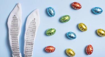 Easter hunt flat lay concept. Creative composition with bunny ears and chocolate eggs photo