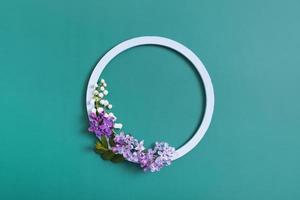 Spring composition. Lily of the valley and lilac flowers with round frame copy space. Summer, spring floral concept
