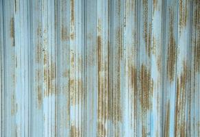 Rusty old and aged blue steel iron sliding store door with stains on it. Wall background textured image. photo