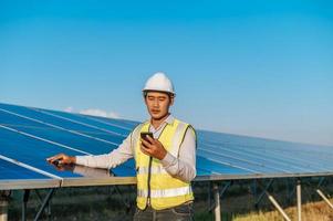 Young engineer use smartphone while working at solar farm