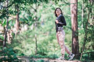 una mujer bonita joven usa una cámara para tomar fotos en un parque natural