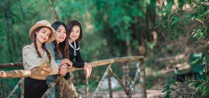 group  young women looking beautiful nature while camping in forest photo