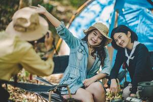 Young photographer use digital camera photography her friend on camping photo