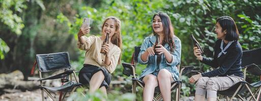 Group of women drink beer and soaked feet in stream photo