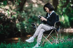 una mujer bonita joven usa una cámara para tomar fotos en un parque natural