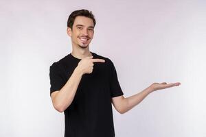 Portrait of happy smiling young man presenting and showing your text or product isolated on white background photo