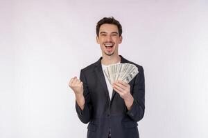 retrato de un hombre alegre que sostiene billetes de dólar y hace gesto de ganador apretando el puño sobre fondo blanco foto