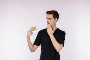 Portrait of Surprised man in casual clothes showing credit card isolated over white background photo