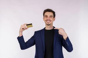 Portrait of Young smiling handsome businessman showing credit card isolated over white background photo