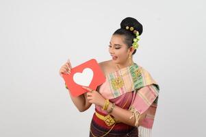 Young beautiful woman in Thai northeastern costume with card in heart symbol photo