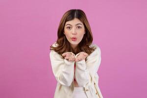 Portrait of Surprised young woman presenting or showing open hand palm with copy space for product over isolated pink background photo