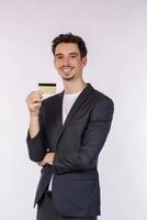 Portrait of Young smiling handsome businessman showing credit card isolated over white background photo