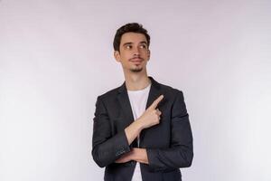 Portrait of young businessman pointing fingers at copy space isolated on white studio background photo