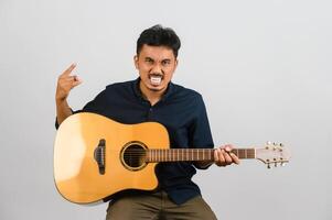 Portrait of Young Asian man playing an acoustic guitar isolated on white background photo