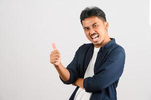 Portrait of Happy young asian man in blue shirt showing thumb up isolated on white background photo