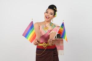 Portrait of Young woman in Thai Northeastern Traditional Clothing holding rainbow flag photo