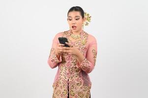 Young beautiful woman dress up in local culture in southern region pose with smartphone photo