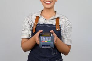 retrato de una joven asiática con uniforme de camarera posando con tarjeta de crédito foto