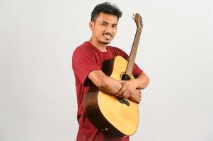 Portrait of Young Asian man in red t-shirt playing an acoustic guitar isolated on white background photo