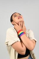 Portrait young asian woman in concept LGBQ with wristband on white background photo