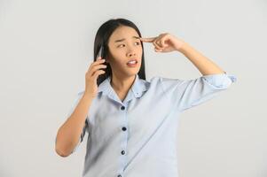 Portrait of Young asian woman talking on mobile phone while standing isolated over white background photo