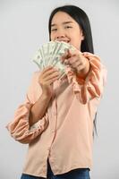 Portrait of a cheerful young woman holding money banknotes and celebrating isolated over white background photo