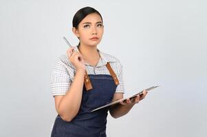 retrato de una joven asiática con uniforme de camarera posa con portapapeles foto