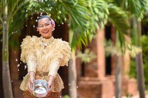 retrato hermosa mujer en el festival de songkran con traje tradicional tailandés foto