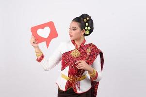joven hermosa mujer en tailandés lanna disfraz con tarjeta tarjeta en corazón símbolo foto