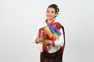 retrato de joven mujer en tailandés del nordeste tradicional ropa participación arco iris bandera foto