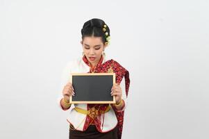 retrato de hermosa tailandés mujer en tradicional ropa posando con pizarra foto