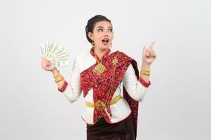 Young beautiful woman in northeastern dress holding fan banknote posting photo