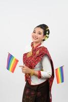 Portrait of Young woman in Thai Northeastern Traditional Clothing holding rainbow flag photo